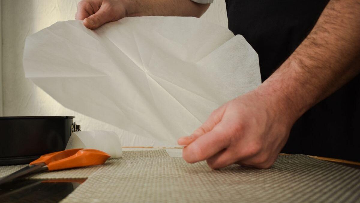 Un uomo con in mano la carta da forno