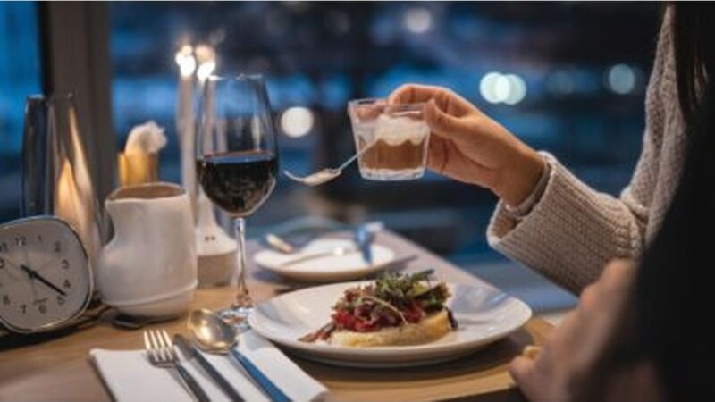 [Persone che cenano tardi in un ristorante affollato]