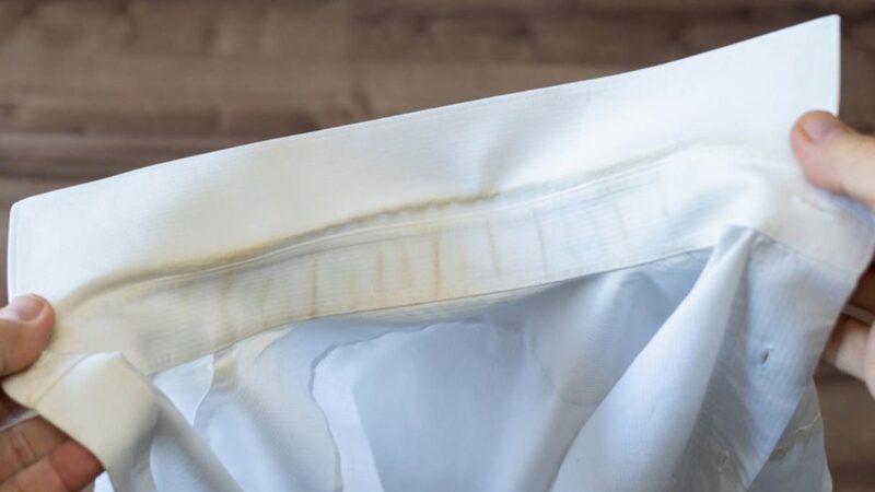 Camicia bianca appesa al sole, priva di macchie e ingiallimento.