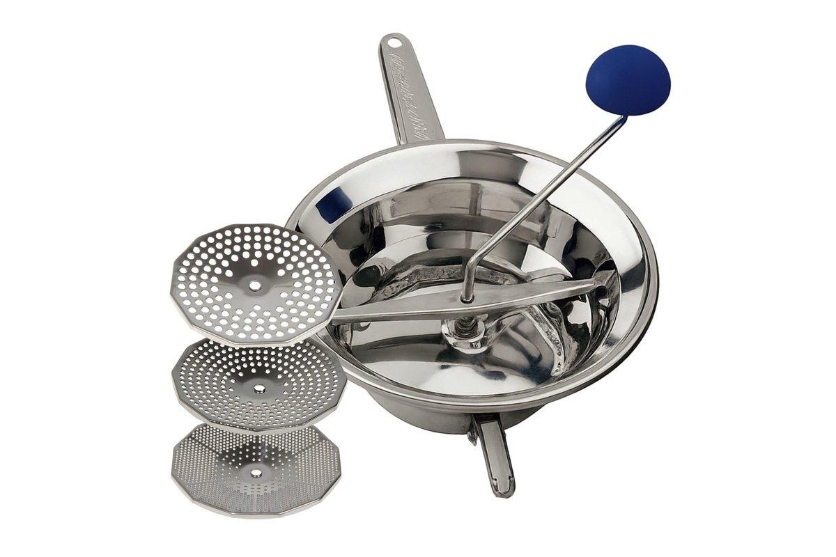 Pentola con vellutata di piselli cremosa e cucchiaio di legno.