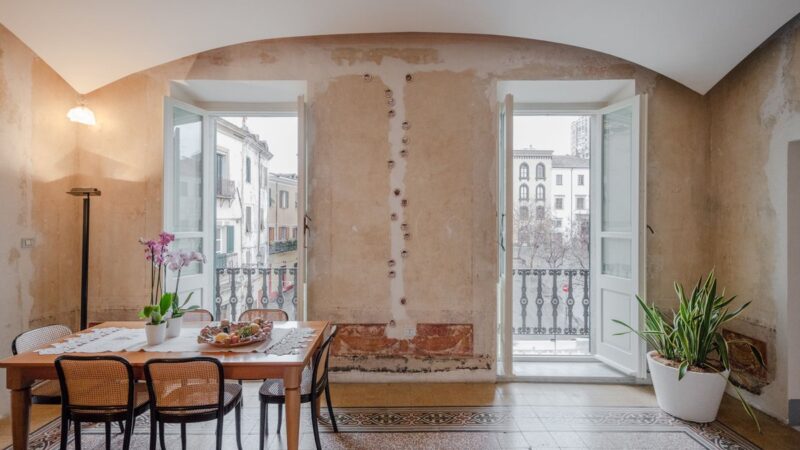 Parete interna con boiserie classica in legno bianco.