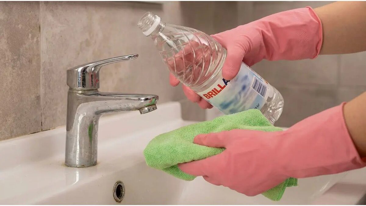 Bottiglia di aceto e panno vicino a una porta del bagno