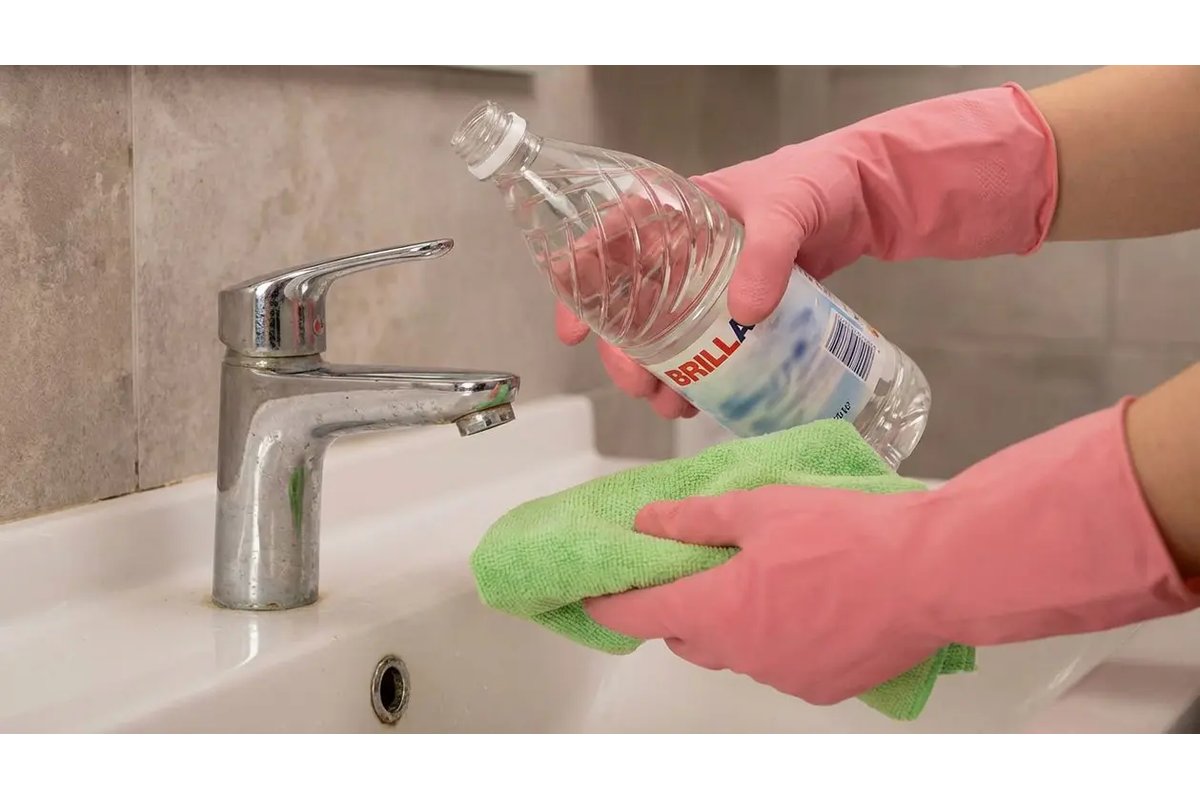 Bottiglia di aceto e panno vicino a una porta del bagno.