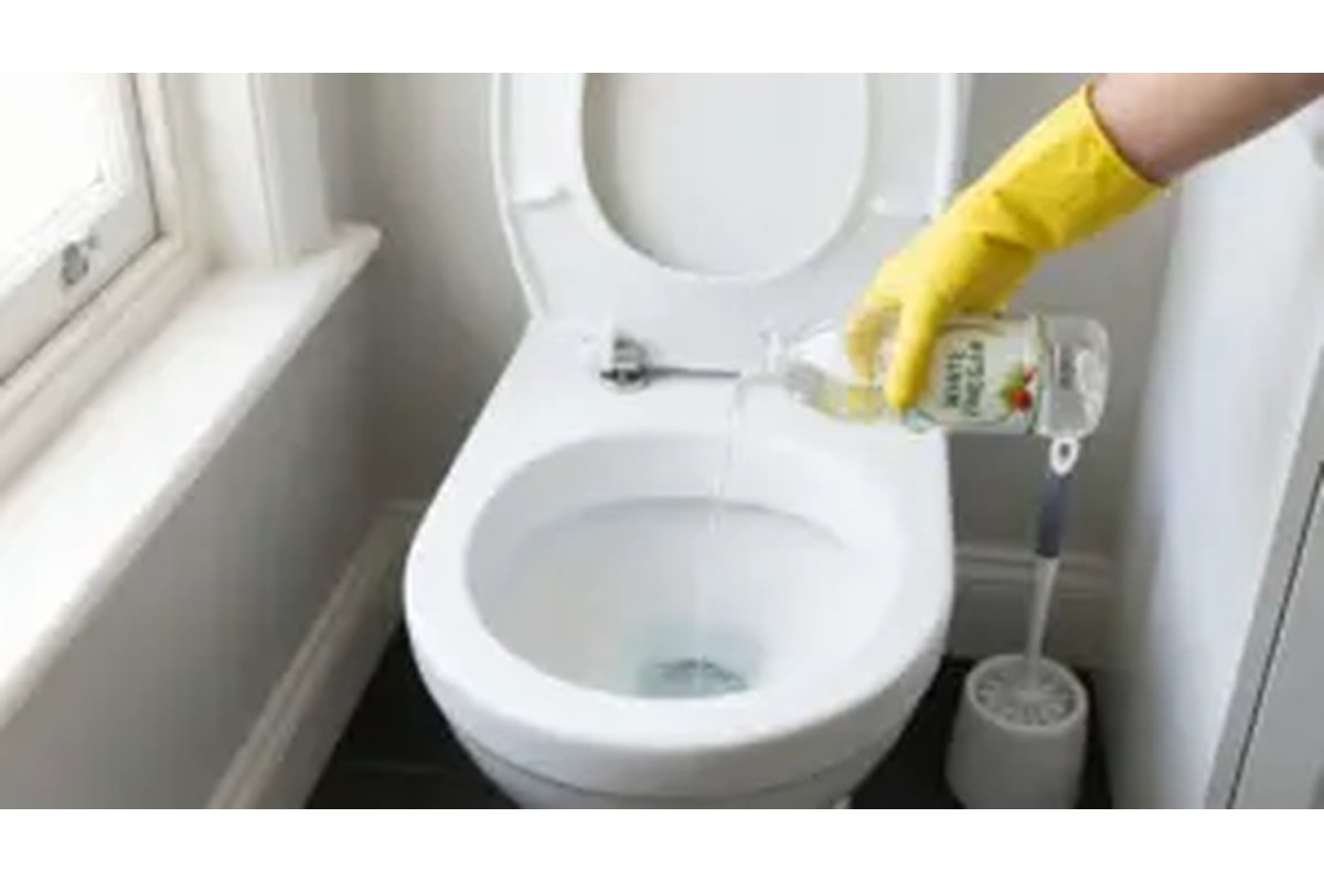 Pulizia della porta del bagno con aceto e panno in microfibra.