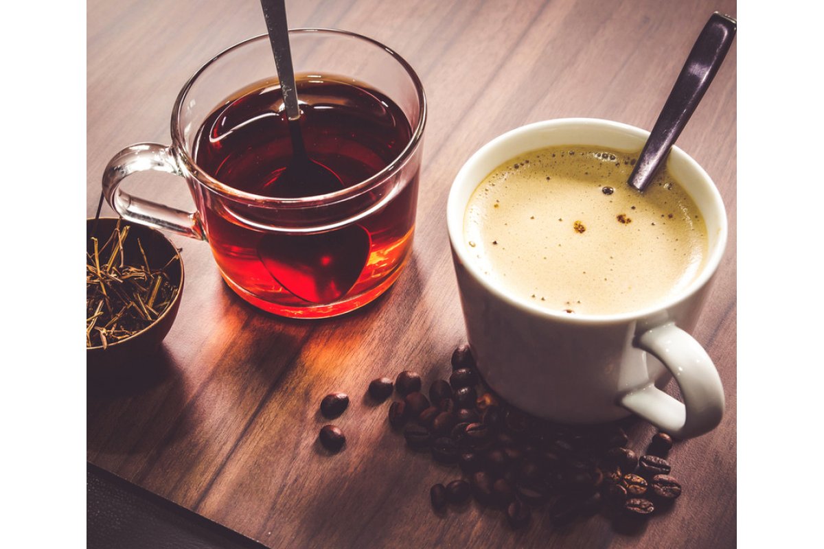Tazza di tè e caffè su un tavolo con sfondo naturale.